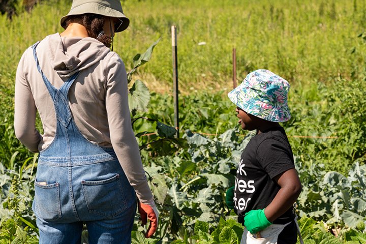 csw-workplace-giving-front-v2 Woman and child wearing hats and talking in a garden.